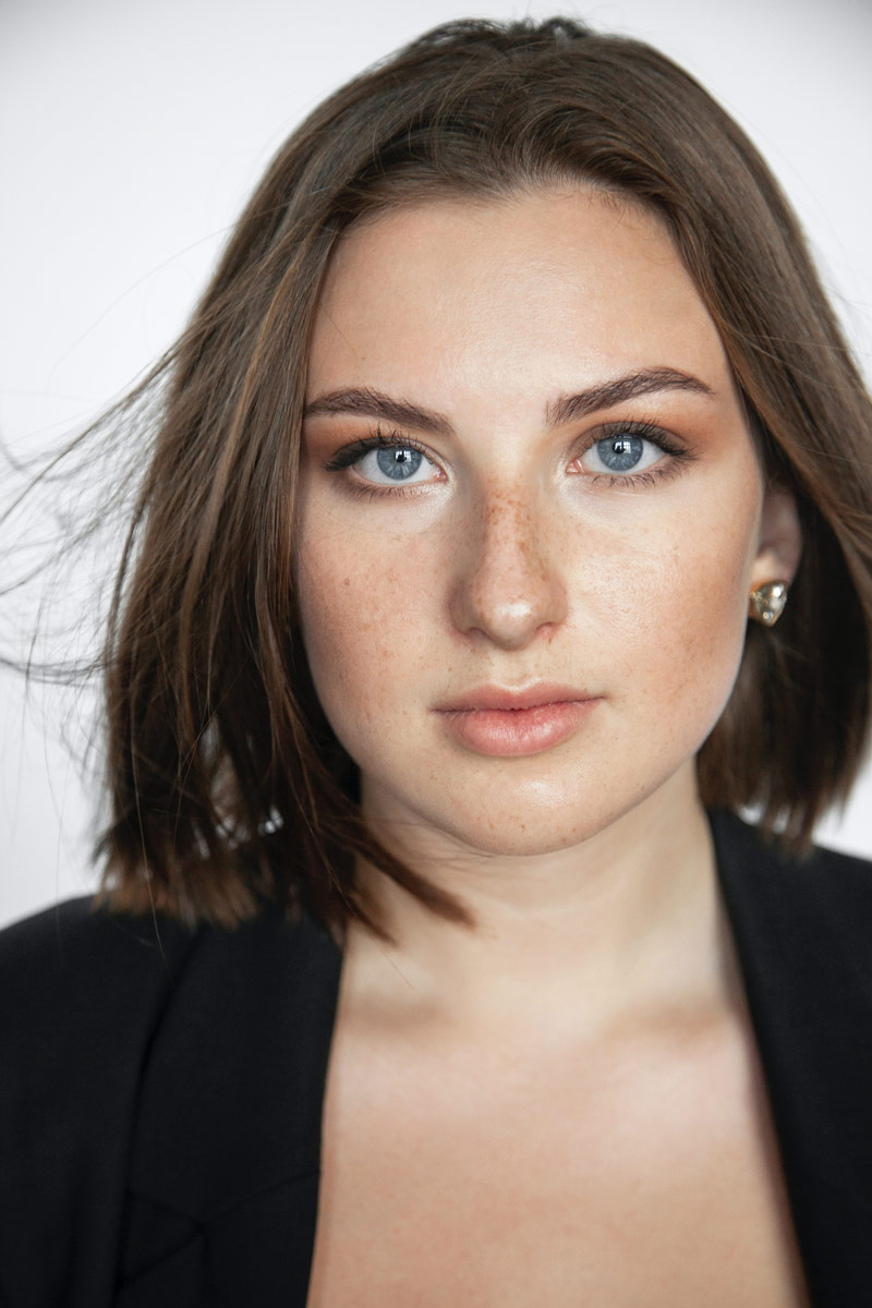 A zoomed face a freckled with blue eyes and short hair woman